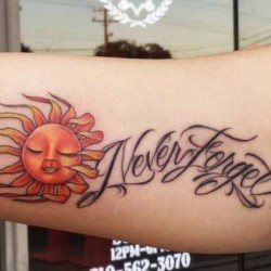 Оранжевое солнце и надпись  на бицепсе (на руке)