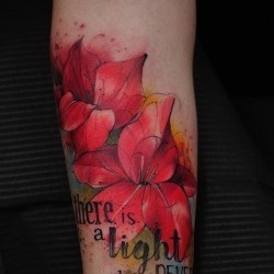 Красная лилия и надпись  на предплечье (на руке)