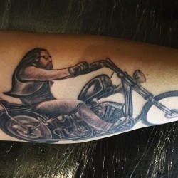 Байкер на мотоцикле  на голени (на ноге)