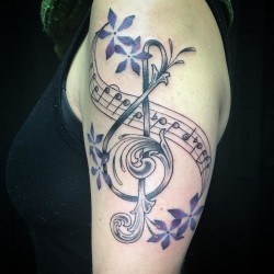 Скрипичный ключ с нотами и цветами  на плече (на руке)
