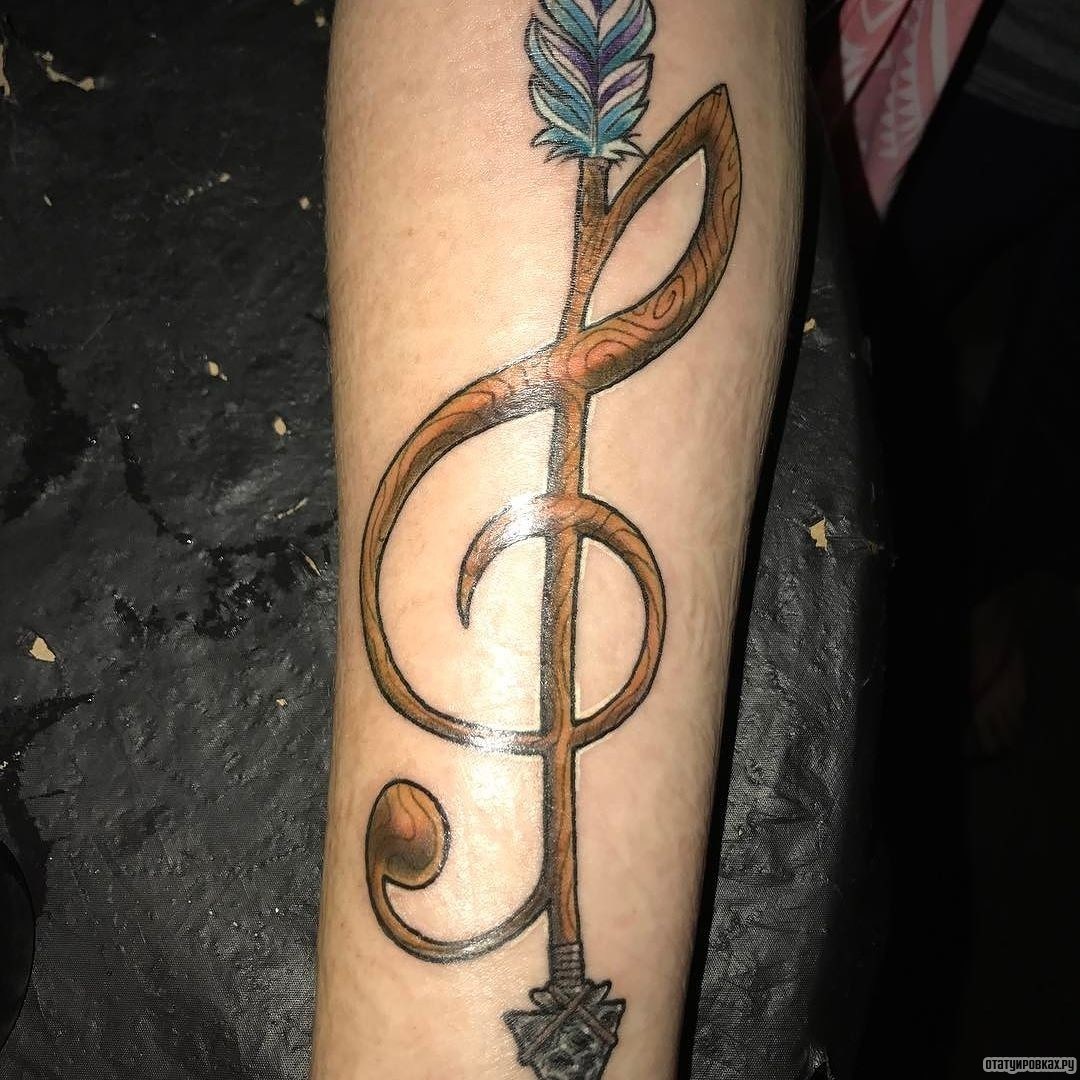 Фотография татуировки под названием «Скрипичный ключ деревянный в виде стрелы»