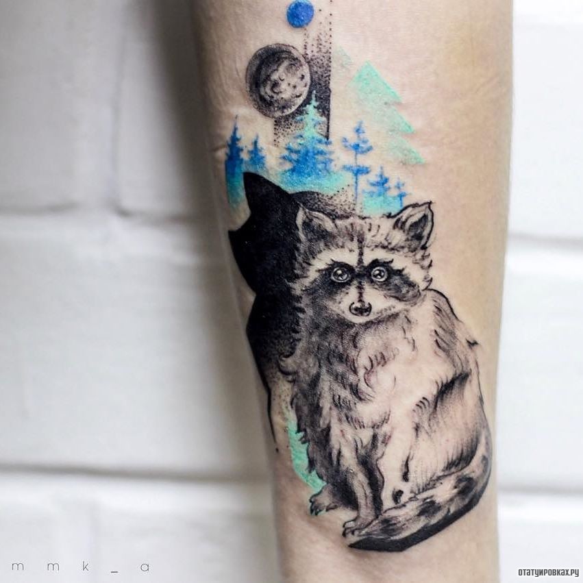 Фотография татуировки под названием «Енот на фоне синего леса»