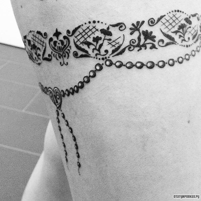 Фотография татуировки под названием «Подвязка с украшениями»