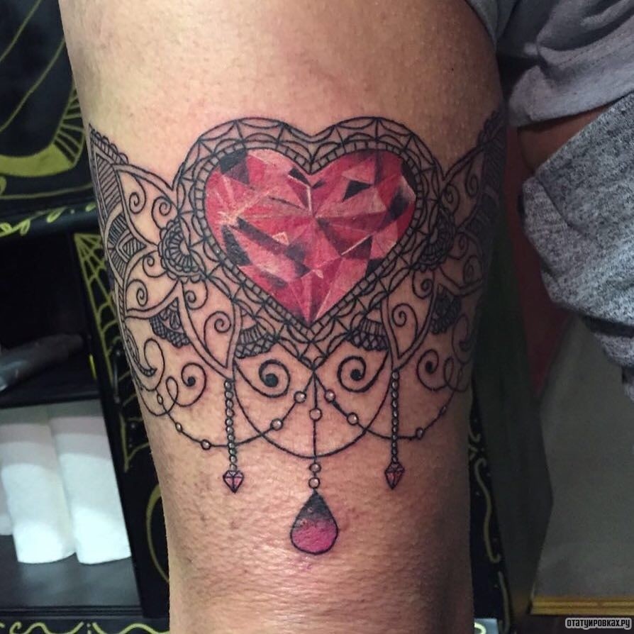 Фотография татуировки под названием «Подвязка - сердце с кристаллом»