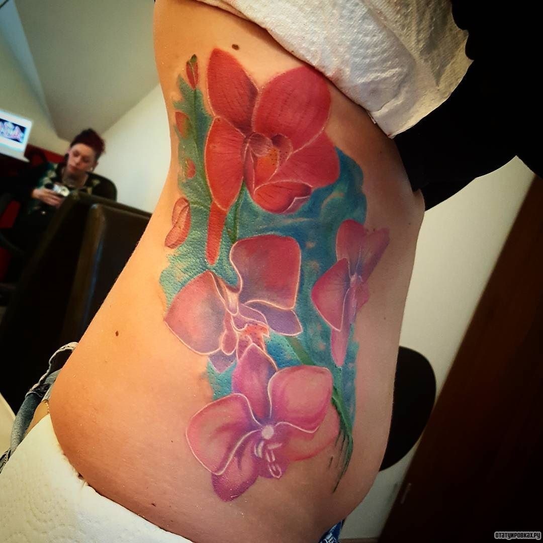 Фотография татуировки под названием «Алая орхидея на голубом фоне»