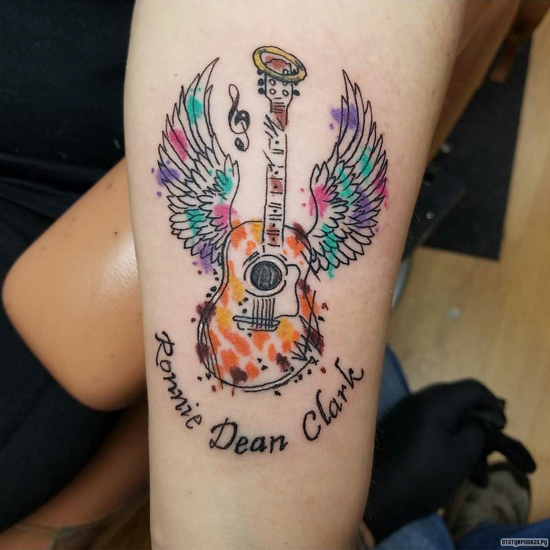 Фотография татуировки под названием «Гитара с крыльями и надписью»