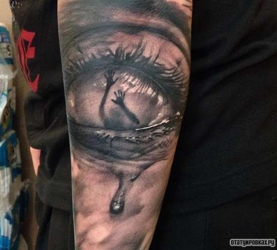 Фотография татуировки под названием «Глаз с руками и слезой»