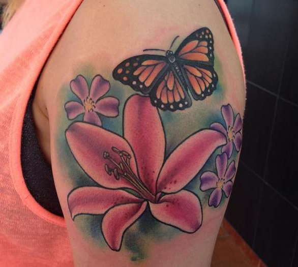 Татуировка лилия с бабочкой на плече девушки
