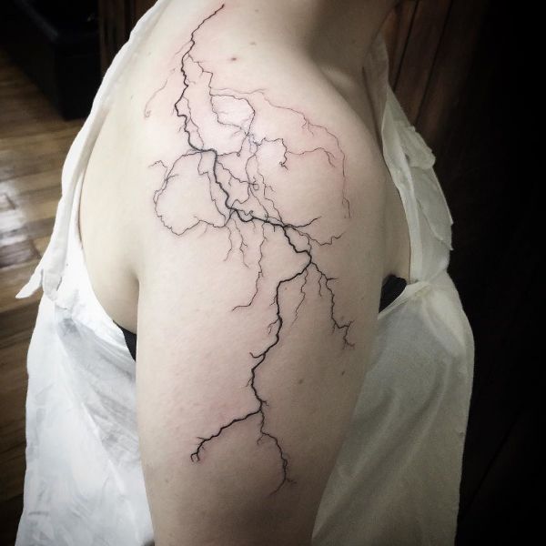 Татуировка молния на плече девушки