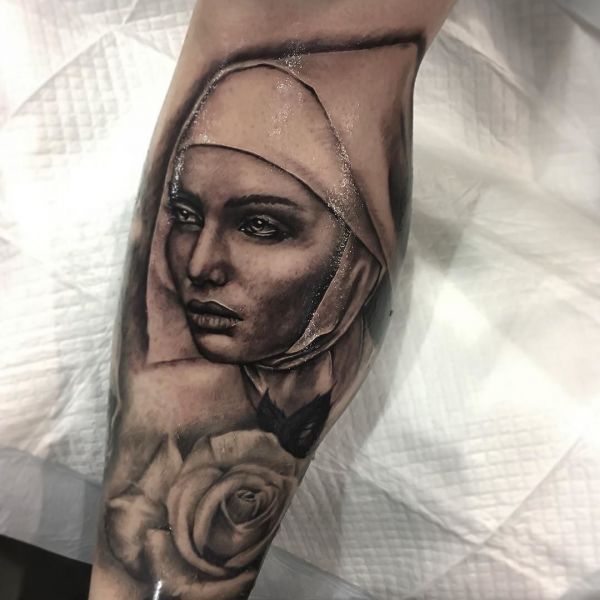 Татуировка монашка с розой на икре