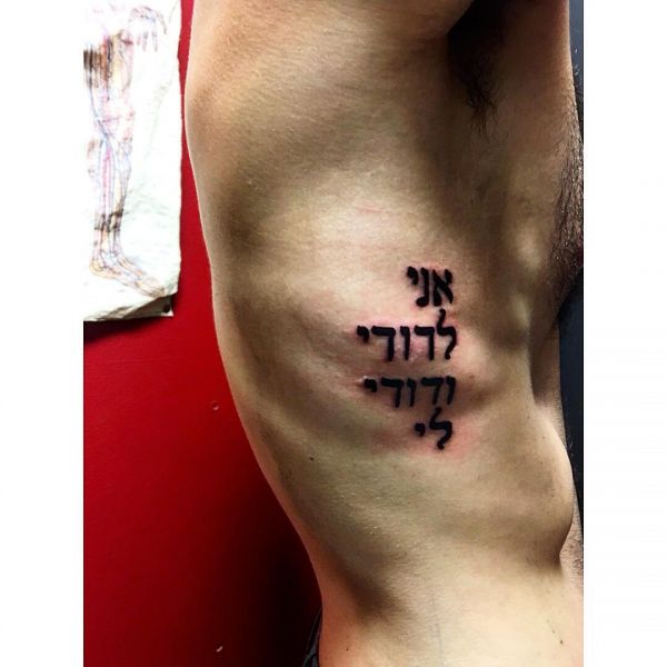 Татуировка надписи на иврите сбоку тела мужчины