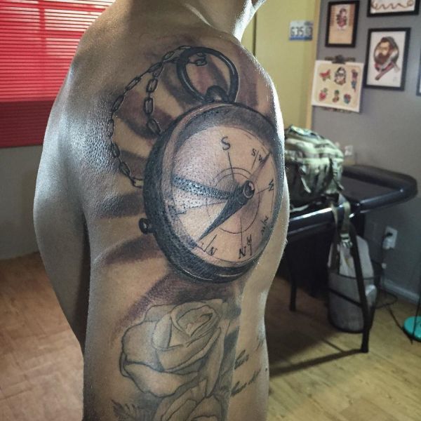 Татуировка большого компаса на плече парня