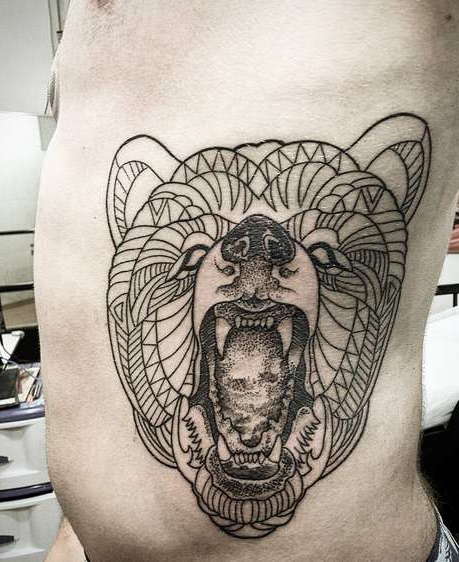 Первый этап нанесения татуировки оскала медведя сбоку тела