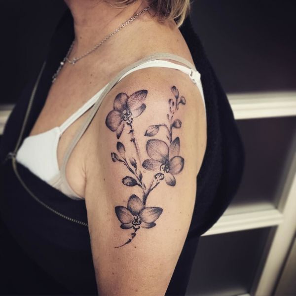 Татуировка орхидея на плече девушки