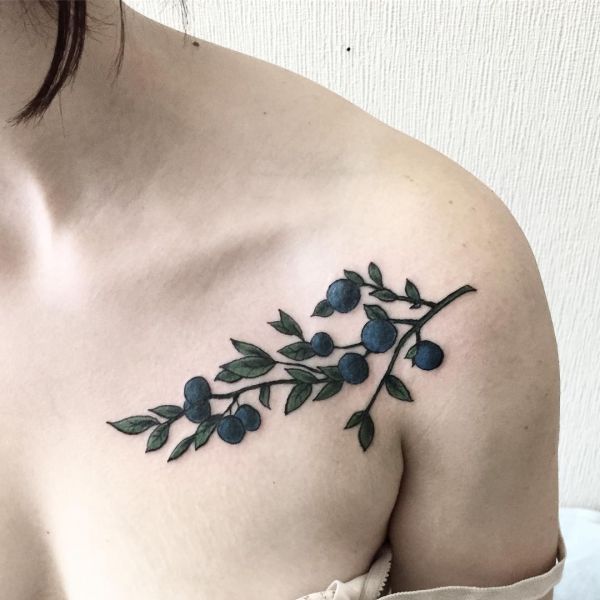 Татуировка ягоды черники на плече девушки