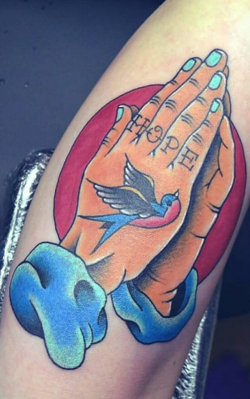 Руки молящегося с ласточкой в цвете - татуировка