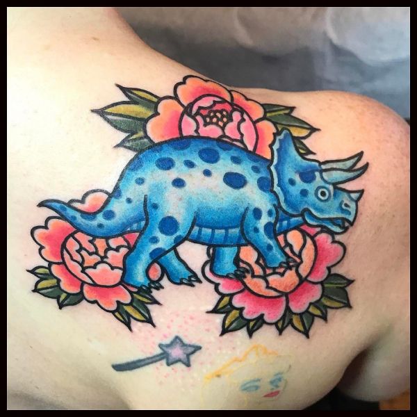 Татуировка синего динозавра с листьями