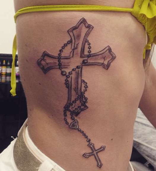 Татуировка крест сбоку тела у девушки