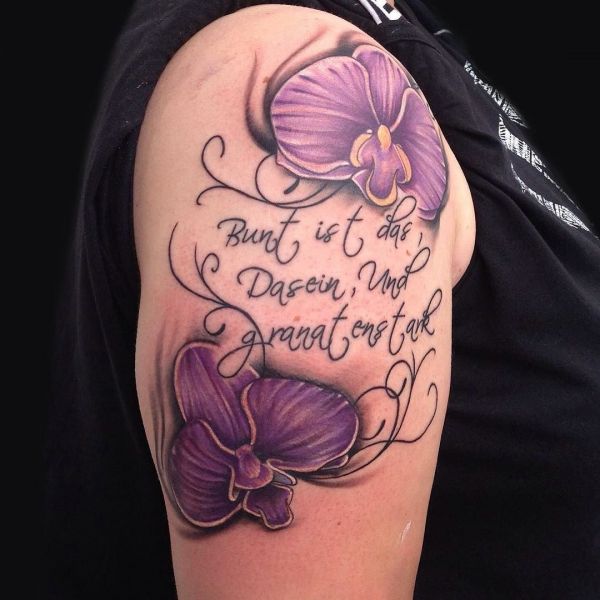 Татуировка сиреневой орхидеи на плече с надписью