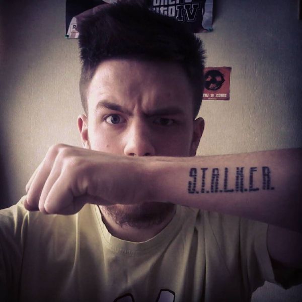 Татуировка надписи сталкер на руке парня