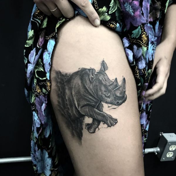 Носорог как татуировка на бедре девушки