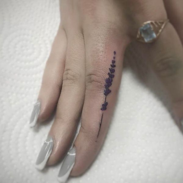 Татуировка сбоку пальца в стиле милимализм у девушки