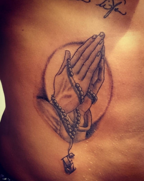 Татуировка в виде рук молящегося сбоку тела