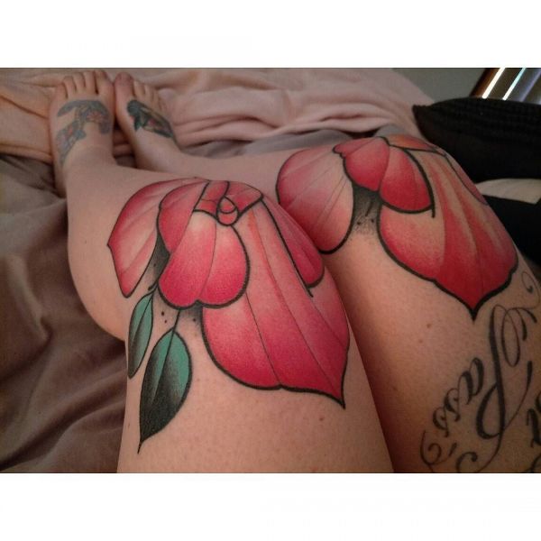 Красные лепестки цветов на коленях девушки