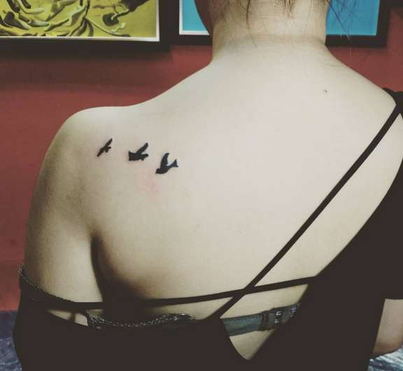 Татуировка птичек на плече у девушки