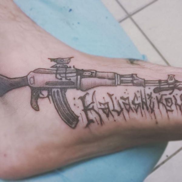 Автомат Калашникова и надпись в виде тату с оружием