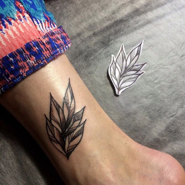Татуировка ветки с листьями у девушки на лодыжке