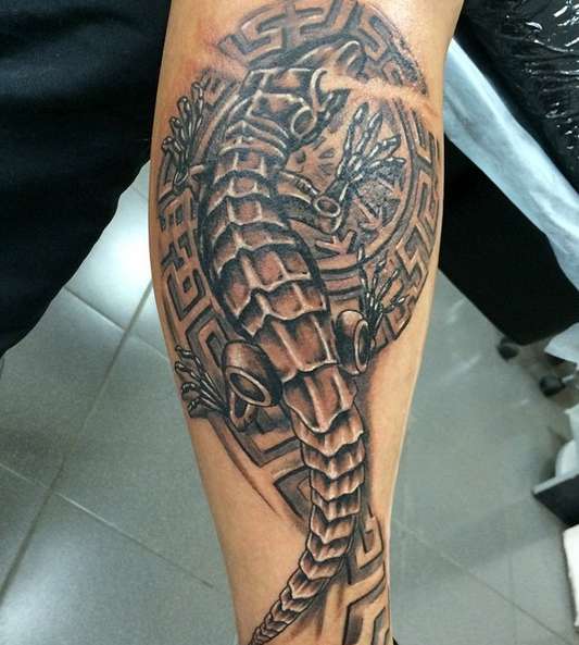 Татуировка ящерицы в полинезийском стиле с узором на плече