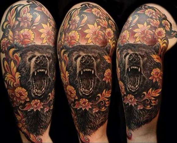 Татуировка оскала медведя с цветами на плече