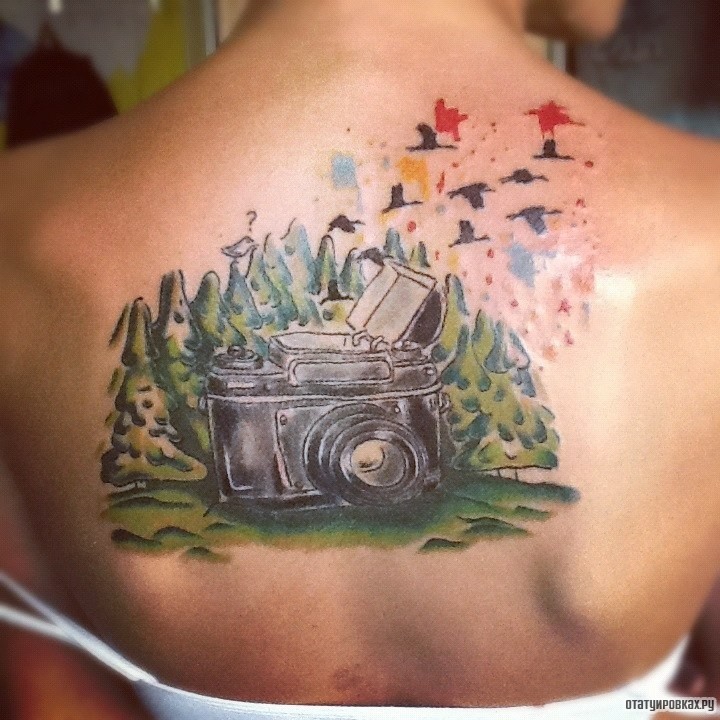 Фотография татуировки под названием «Фотоаппарат на фоне елок»