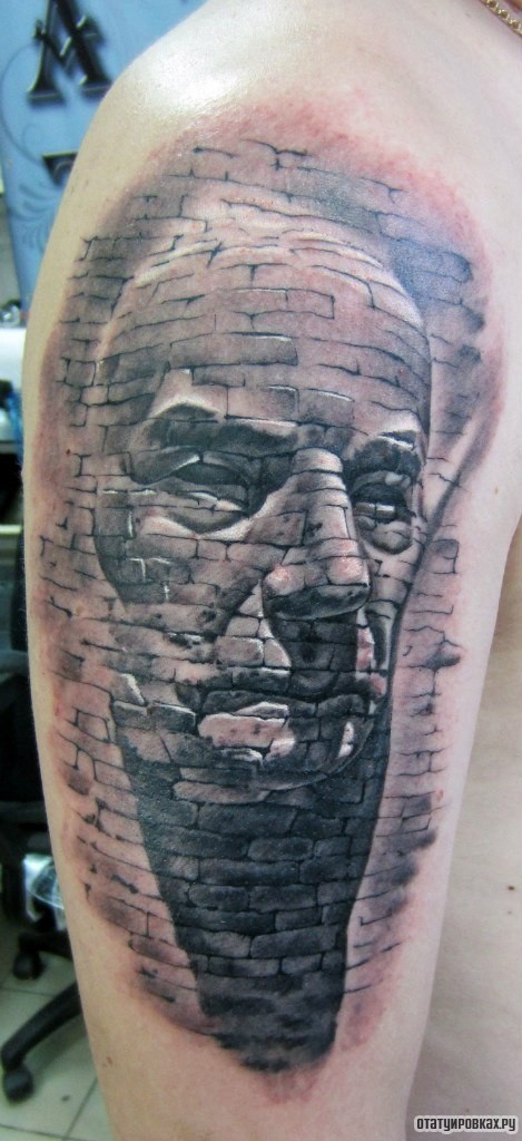 Фотография татуировки под названием «Лицо человека в стене»