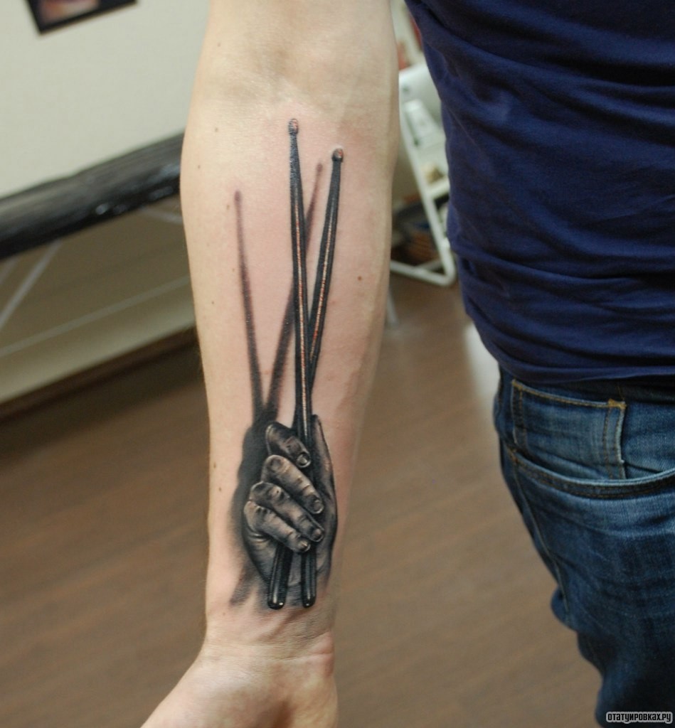 Фотография татуировки под названием «Рука с барабанными палочками»