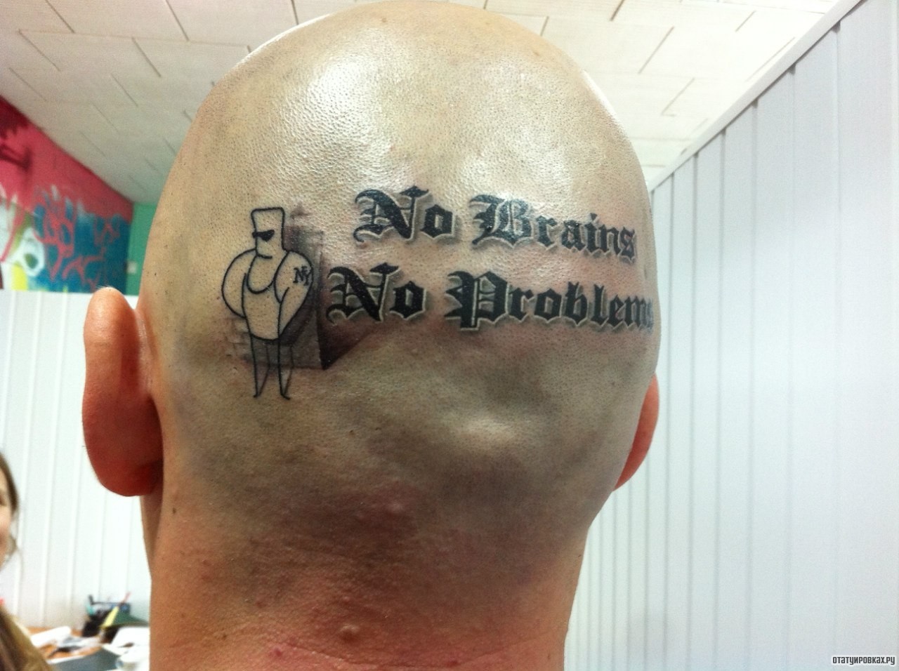 Фотография татуировки под названием «Надпись с человечком на голове»