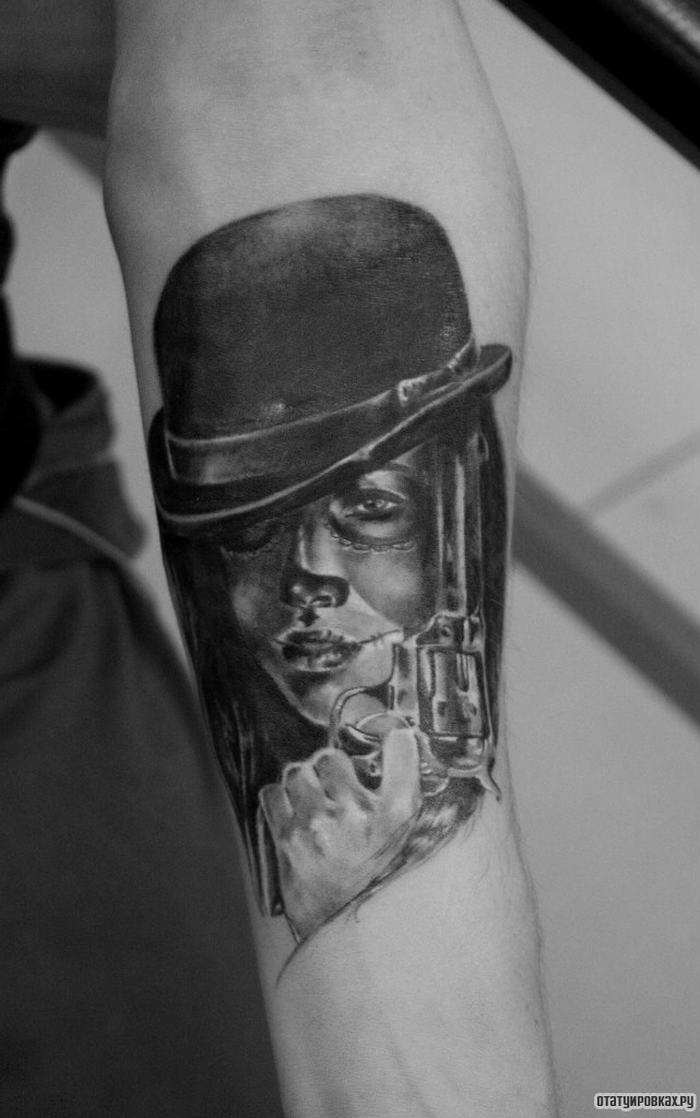 Фотография татуировки под названием «Девушка в шляпе с пистолетом чикано»