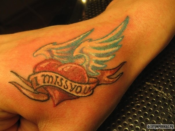 Фотография татуировки под названием «Сердце с крыльями и надпись i muss you»