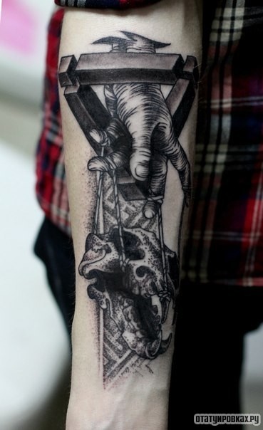 Фотография татуировки под названием «Рука играет черепом животного»