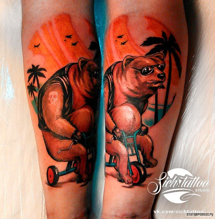 Фотография татуировки под названием «Медведь на велосипеде на фоне пальм»