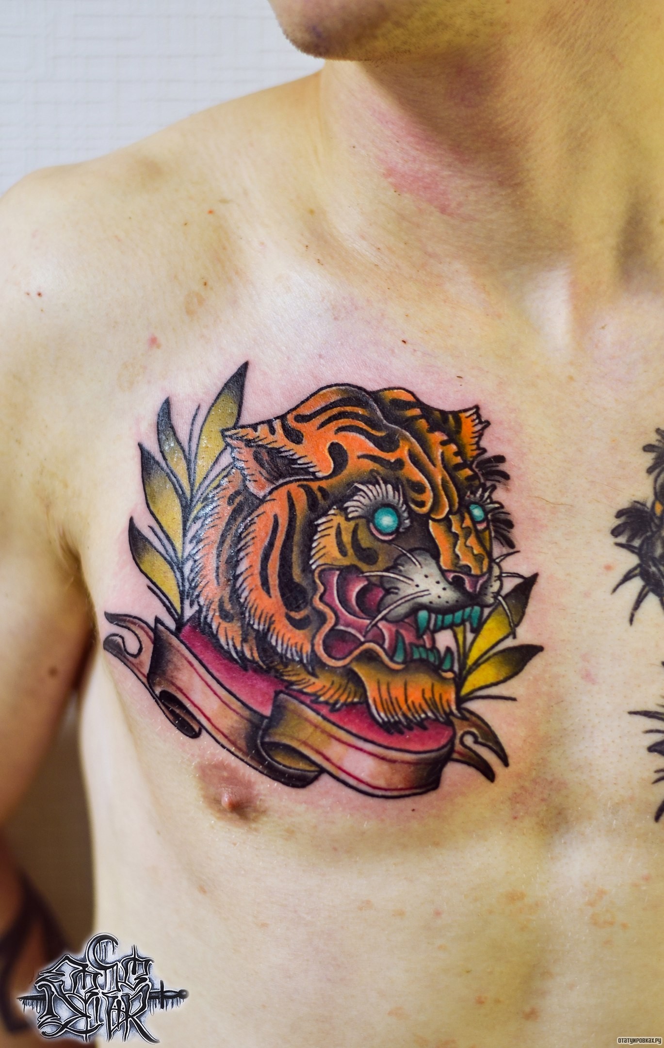 Фотография татуировки под названием «Тигр с лентой и веткой»