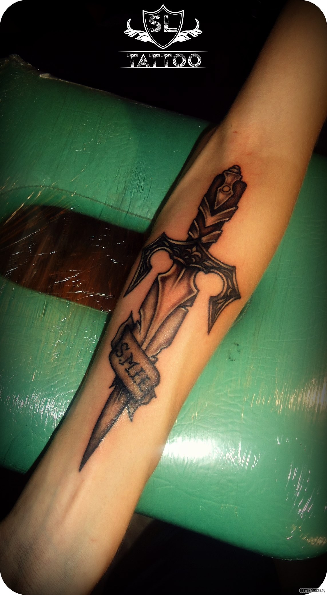 Фотография татуировки под названием «Кинжал и надпись»