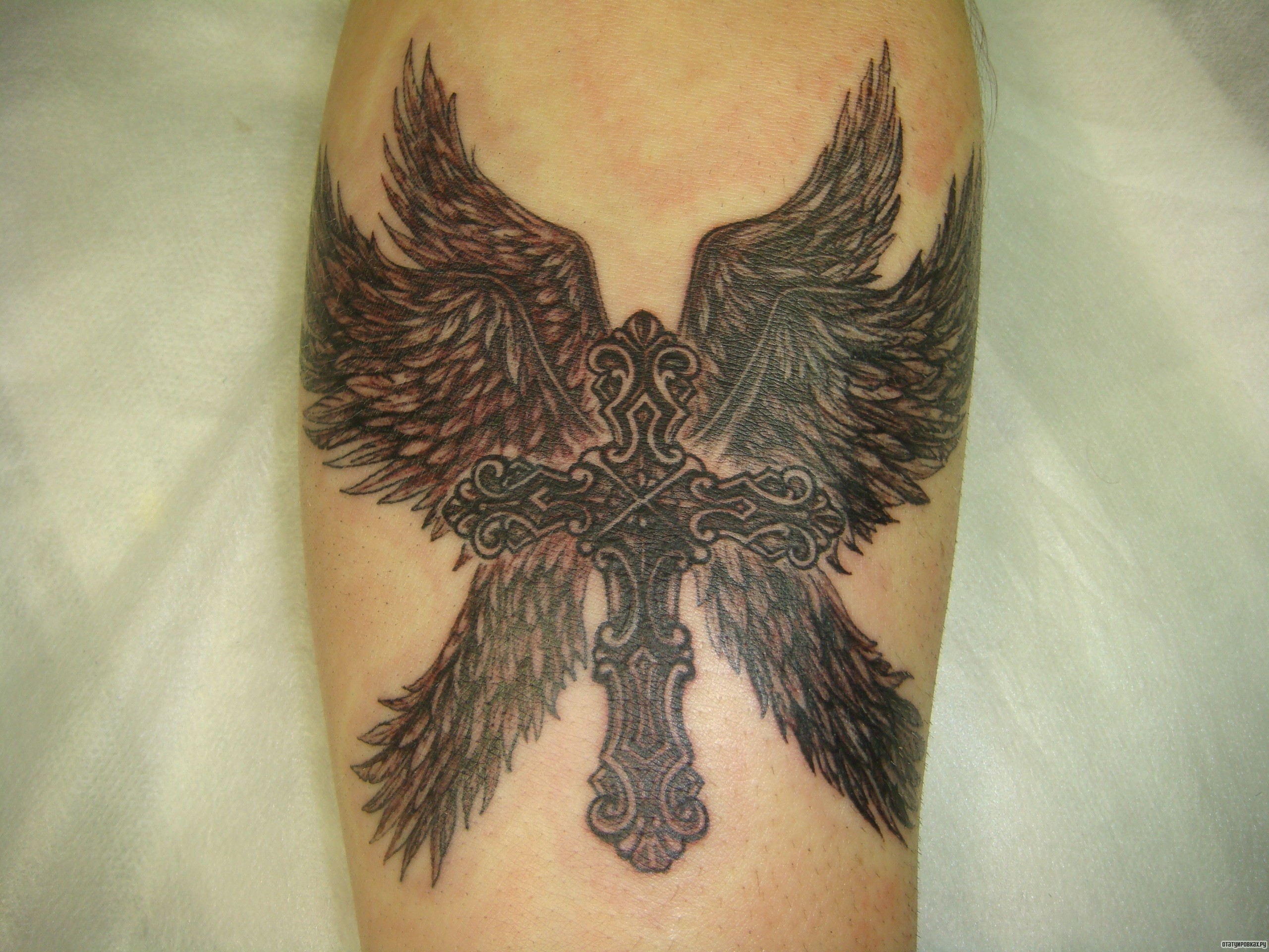 Фотография татуировки под названием «Крест с четырьми крыльями»