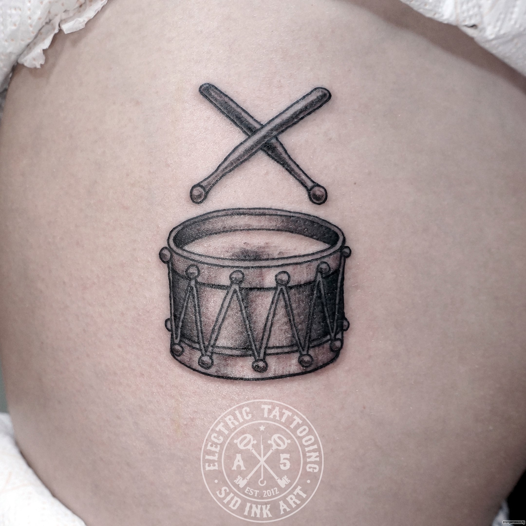 Фотография татуировки под названием «Барабан с палочками»
