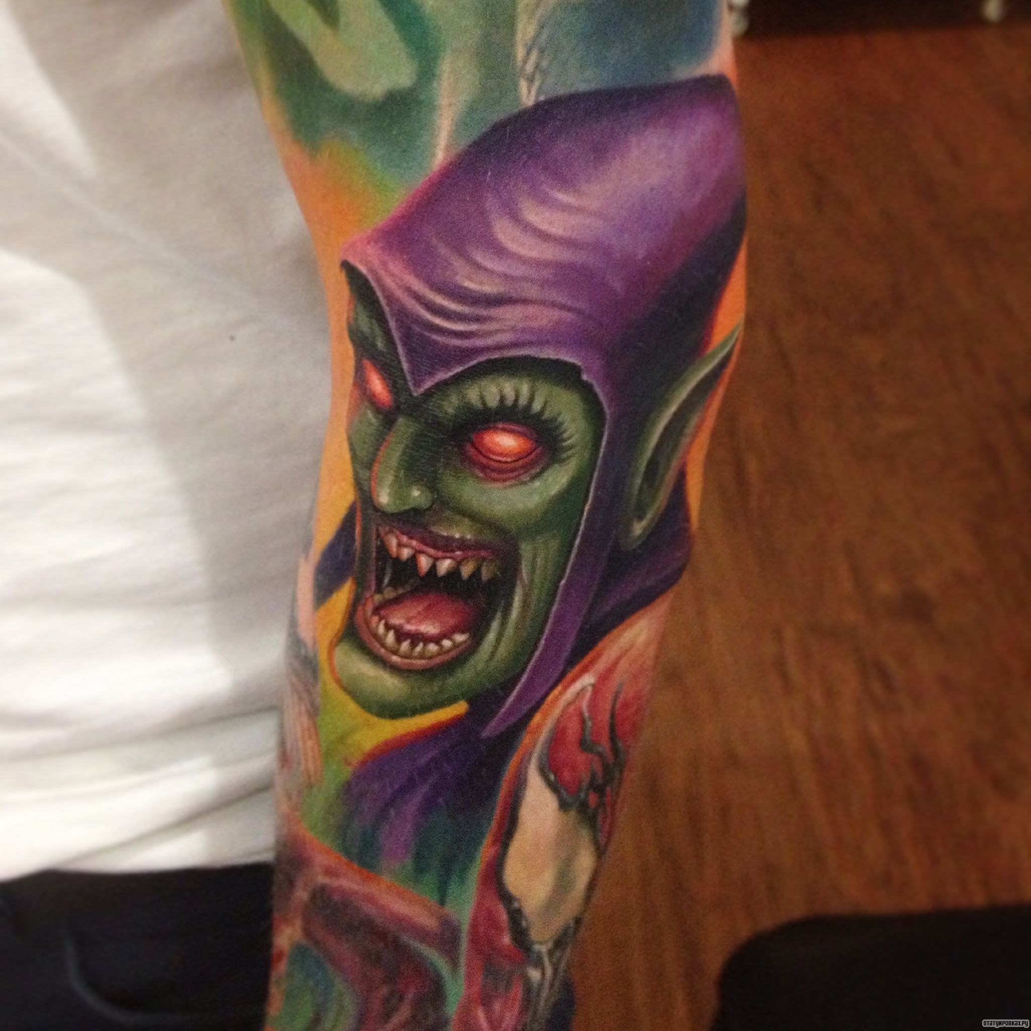 Фотография татуировки под названием «Зеленый человек в фиолетовом плаще»
