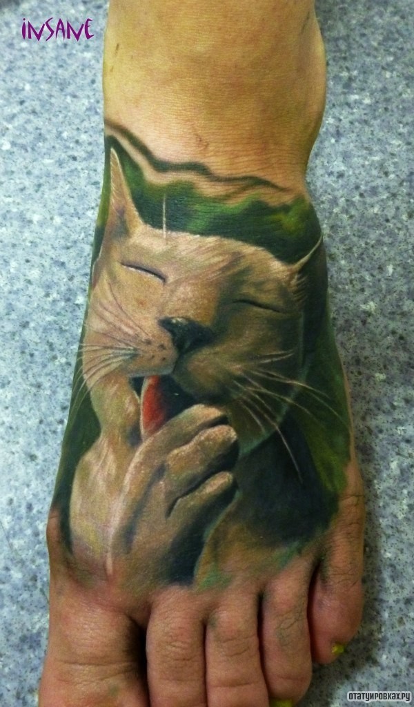 Фотография татуировки под названием «Кот лижет лапу»