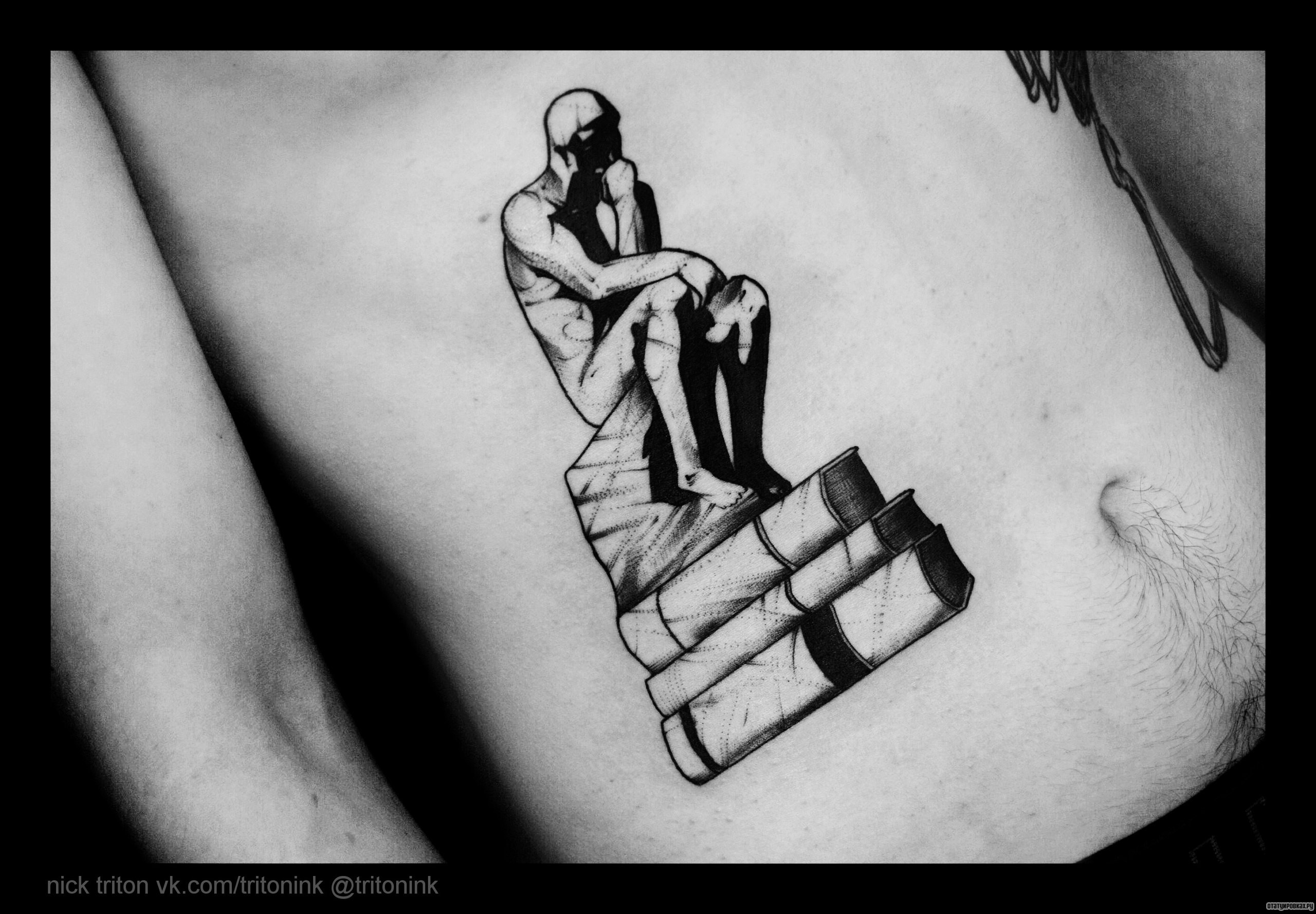 Фотография татуировки под названием «Человек сидит на книгах»