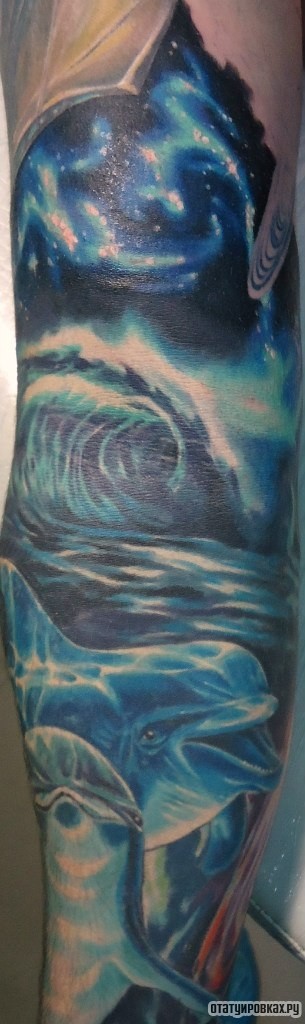 Фотография татуировки под названием «Млечный путь, волны и дельфины»