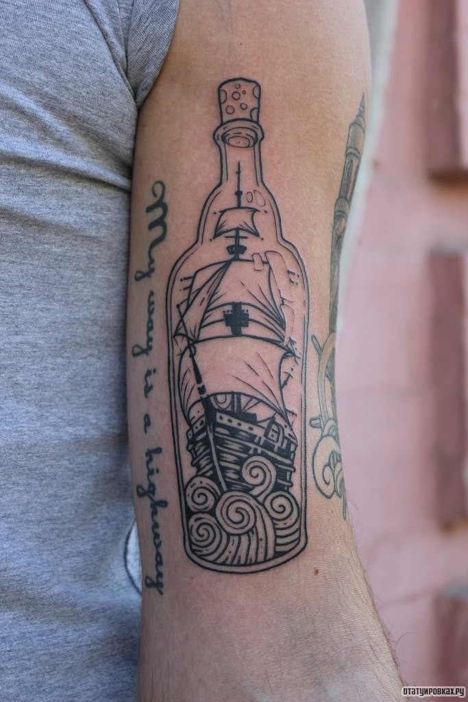 Фотография татуировки под названием «Корабль в бутылке и надпись»